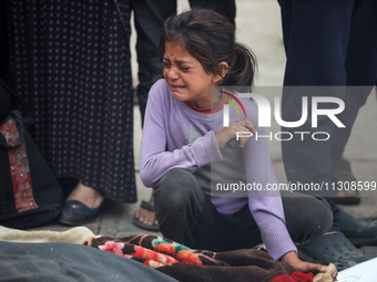 Relatives are mourning over the bodies of people killed in an Israeli airstrike at a UN school housing displaced Palestinians in Nuseirat, a...