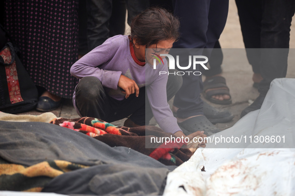 Relatives are mourning over the bodies of people killed in an Israeli airstrike at a UN school housing displaced Palestinians in Nuseirat, a...