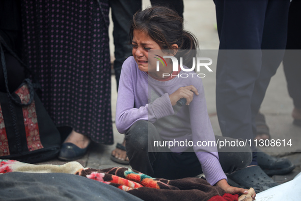 Relatives are mourning over the bodies of people killed in an Israeli airstrike at a UN school housing displaced Palestinians in Nuseirat, a...