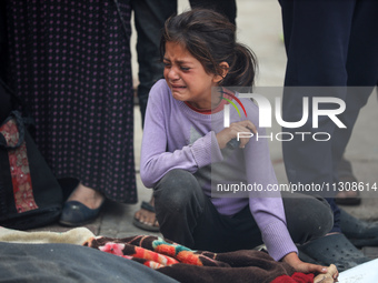 Relatives are mourning over the bodies of people killed in an Israeli airstrike at a UN school housing displaced Palestinians in Nuseirat, a...