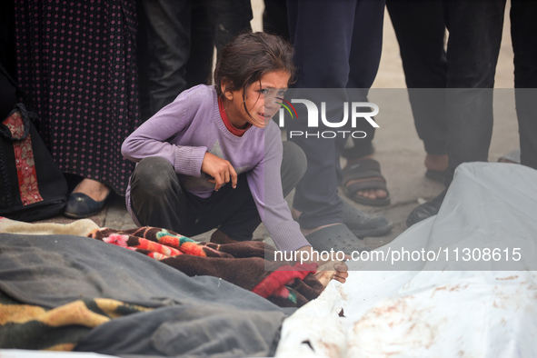 Relatives are mourning over the bodies of people killed in an Israeli airstrike at a UN school housing displaced Palestinians in Nuseirat, a...