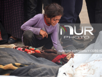 Relatives are mourning over the bodies of people killed in an Israeli airstrike at a UN school housing displaced Palestinians in Nuseirat, a...