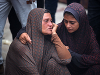 Relatives are mourning over the bodies of people killed in an Israeli airstrike at a UN school housing displaced Palestinians in Nuseirat, a...