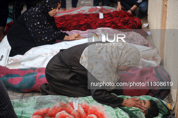 Relatives are mourning over the bodies of people killed in an Israeli airstrike at a UN school housing displaced Palestinians in Nuseirat, a...