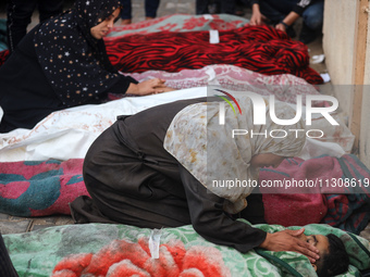 Relatives are mourning over the bodies of people killed in an Israeli airstrike at a UN school housing displaced Palestinians in Nuseirat, a...