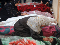 Relatives are mourning over the bodies of people killed in an Israeli airstrike at a UN school housing displaced Palestinians in Nuseirat, a...