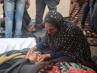 Relatives are mourning over the bodies of people killed in an Israeli airstrike at a UN school housing displaced Palestinians in Nuseirat, a...