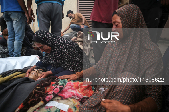 Relatives are mourning over the bodies of people killed in an Israeli airstrike at a UN school housing displaced Palestinians in Nuseirat, a...