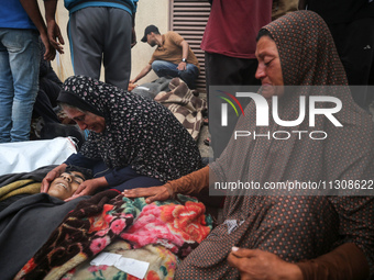 Relatives are mourning over the bodies of people killed in an Israeli airstrike at a UN school housing displaced Palestinians in Nuseirat, a...