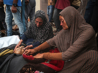 Relatives are mourning over the bodies of people killed in an Israeli airstrike at a UN school housing displaced Palestinians in Nuseirat, a...