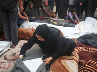 Relatives are mourning over the bodies of people killed in an Israeli airstrike at a UN school housing displaced Palestinians in Nuseirat, a...