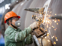 A worker is producing various types of pressure vessel equipment at a pressure vessel workshop in Nantong, Jiangsu province, China, on June...