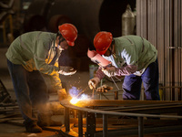 A worker is producing various types of pressure vessel equipment at a pressure vessel workshop in Nantong, Jiangsu province, China, on June...