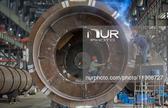 A worker is producing various types of pressure vessel equipment at a pressure vessel workshop in Nantong, Jiangsu province, China, on June...