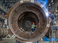 A worker is producing various types of pressure vessel equipment at a pressure vessel workshop in Nantong, Jiangsu province, China, on June...