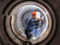 A worker is producing various types of pressure vessel equipment at a pressure vessel workshop in Nantong, Jiangsu province, China, on June...