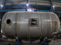 A worker is producing various types of pressure vessel equipment at a pressure vessel workshop in Nantong, Jiangsu province, China, on June...