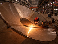 A worker is producing various types of pressure vessel equipment at a pressure vessel workshop in Nantong, Jiangsu province, China, on June...