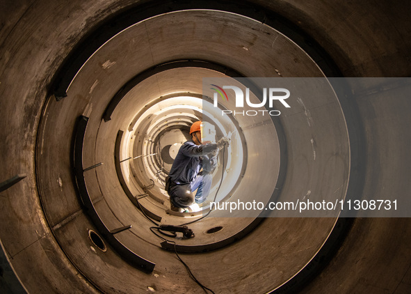 A worker is producing various types of pressure vessel equipment at a pressure vessel workshop in Nantong, Jiangsu province, China, on June...