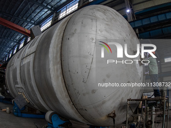 A worker is producing various types of pressure vessel equipment at a pressure vessel workshop in Nantong, Jiangsu province, China, on June...