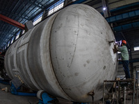 A worker is producing various types of pressure vessel equipment at a pressure vessel workshop in Nantong, Jiangsu province, China, on June...