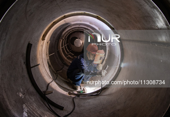 A worker is producing various types of pressure vessel equipment at a pressure vessel workshop in Nantong, Jiangsu province, China, on June...