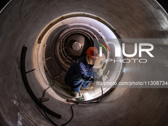 A worker is producing various types of pressure vessel equipment at a pressure vessel workshop in Nantong, Jiangsu province, China, on June...