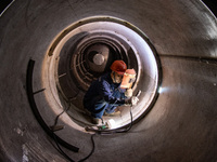 A worker is producing various types of pressure vessel equipment at a pressure vessel workshop in Nantong, Jiangsu province, China, on June...