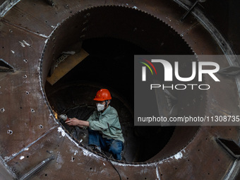 A worker is producing various types of pressure vessel equipment at a pressure vessel workshop in Nantong, Jiangsu province, China, on June...