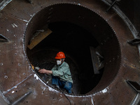 A worker is producing various types of pressure vessel equipment at a pressure vessel workshop in Nantong, Jiangsu province, China, on June...