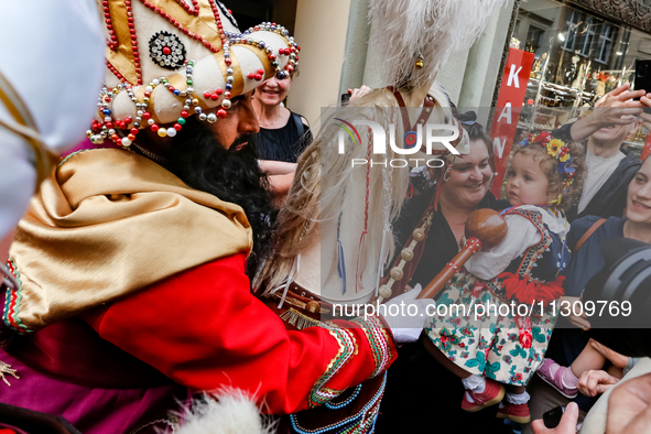 Lajkonik, a folklore symbol of Krakow, touches a girl with a mace for good luck as he walks in a parade during the Lajkonik March in the Old...