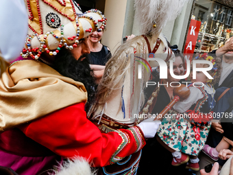 Lajkonik, a folklore symbol of Krakow, touches a girl with a mace for good luck as he walks in a parade during the Lajkonik March in the Old...