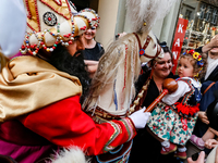 Lajkonik, a folklore symbol of Krakow, touches a girl with a mace for good luck as he walks in a parade during the Lajkonik March in the Old...