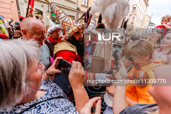 Lajkonik, a folklore symbol of Krakow, touches a woman with a mace for good luck as he walks in a parade during the Lajkonik March in the Ol...