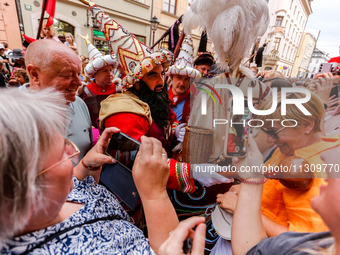 Lajkonik, a folklore symbol of Krakow, touches a woman with a mace for good luck as he walks in a parade during the Lajkonik March in the Ol...