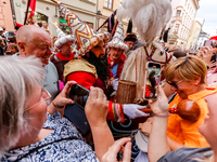 Lajkonik, a folklore symbol of Krakow, touches a woman with a mace for good luck as he walks in a parade during the Lajkonik March in the Ol...