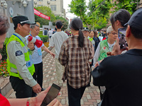 Volunteers are maintaining order as students are entering a test room to take part in the National college entrance examination in Shanghai,...