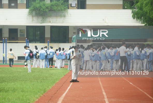 Candidates are waiting outside a test site for the National College Entrance examination in Hangzhou, China, on June 7, 2024. 