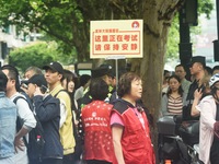 Volunteers are reminding passers-by to keep quiet outside a college entrance exam in Hangzhou, China, on June 7, 2024. (