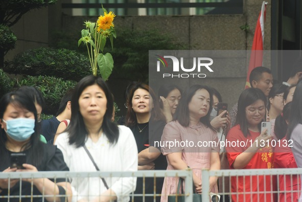 Parents are waiting outside a college entrance examination point in Hangzhou, Zhejiang province, China, on June 7, 2024. 