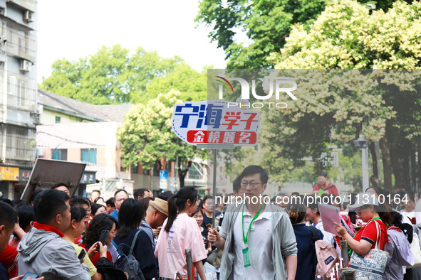 A teacher is presenting a placard to bless examinees in Nanjing, China, on June 7, 2024. According to data released by the Ministry of Educa...