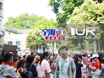 A teacher is presenting a placard to bless examinees in Nanjing, China, on June 7, 2024. According to data released by the Ministry of Educa...