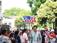 A teacher is presenting a placard to bless examinees in Nanjing, China, on June 7, 2024. According to data released by the Ministry of Educa...