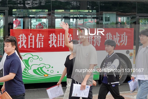 Candidates for the National College entrance examination are waving to teachers delivering exams outside a college entrance examination site...