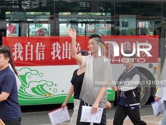 Candidates for the National College entrance examination are waving to teachers delivering exams outside a college entrance examination site...