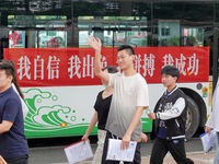 Candidates for the National College entrance examination are waving to teachers delivering exams outside a college entrance examination site...