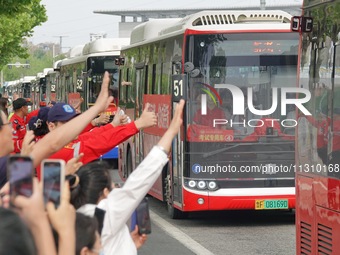 Citizens and volunteers are cheering for gaokao candidates outside a college entrance exam site in Yantai, China, on June 7, 2024. (