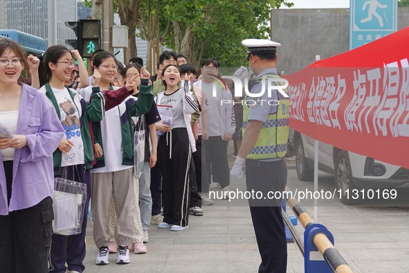 Traffic police on duty are cheering for gaokao candidates outside a college entrance exam site in Yantai, China, on June 7, 2024. 