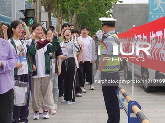 Traffic police on duty are cheering for gaokao candidates outside a college entrance exam site in Yantai, China, on June 7, 2024. (