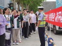 Traffic police on duty are cheering for gaokao candidates outside a college entrance exam site in Yantai, China, on June 7, 2024. (